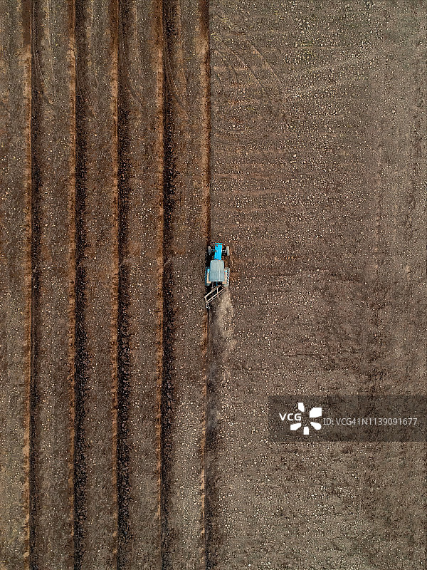 拖拉机驱动土壤农业区鸟瞰图。图片素材
