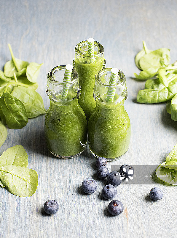三瓶菠菜和蓝莓绿色冰沙图片素材