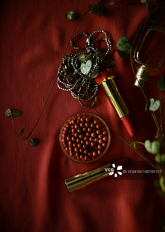 两支口红，一条项链，古铜色粉末和一个红底色香水瓶图片素材