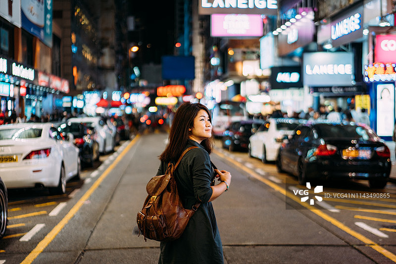 中国香港的一名年轻女子在晚上进入旺角市场图片素材