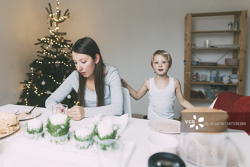 圣诞节的时候，一个女人带着小儿子在厨房里图片素材
