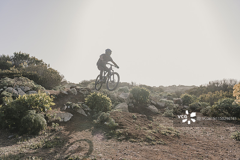 西班牙，兰萨罗特，在沙漠中骑行的登山运动员图片素材