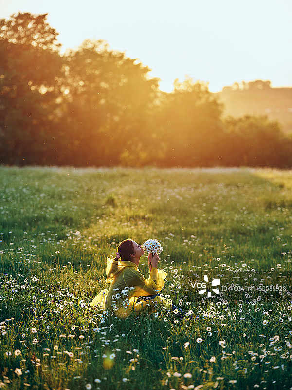 少女在雏菊的田野里，美丽的晚霞图片素材