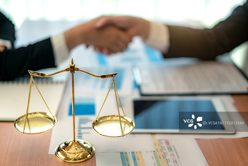 男律师与商务女性客户之间的良好服务合作，在达成协议后握手，法律和法律理念。图片素材