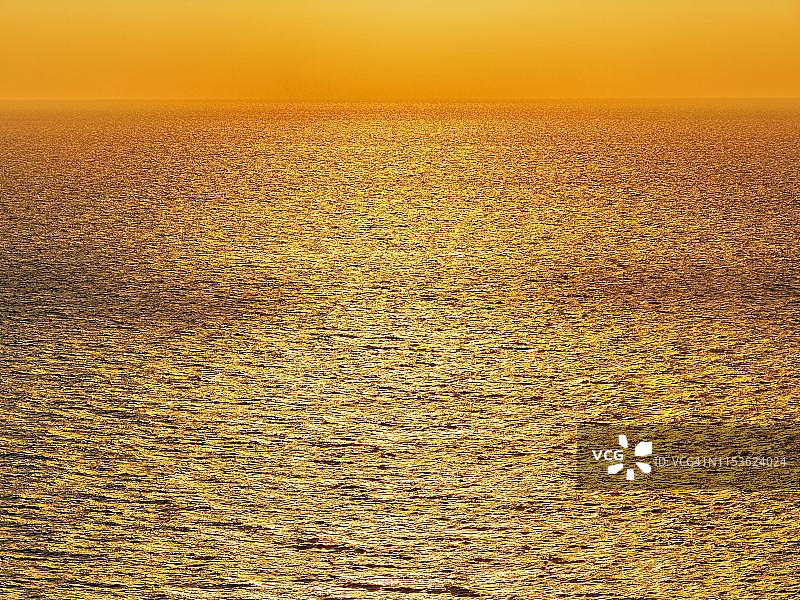 金色的夕阳在海面上，阳光在海浪上闪闪发光，圣托里尼，希腊圣托里尼图片素材