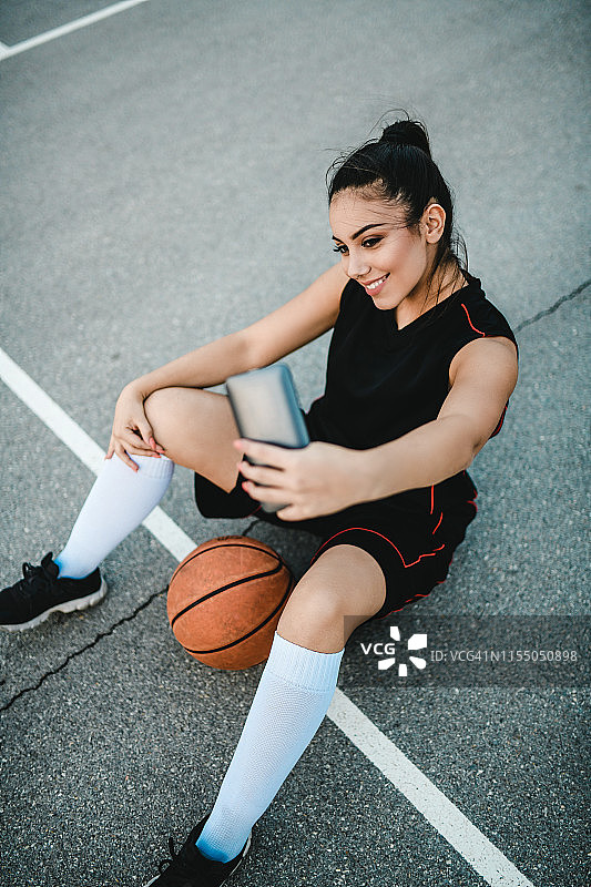 美丽的女篮球运动员在球场上与球自拍图片素材