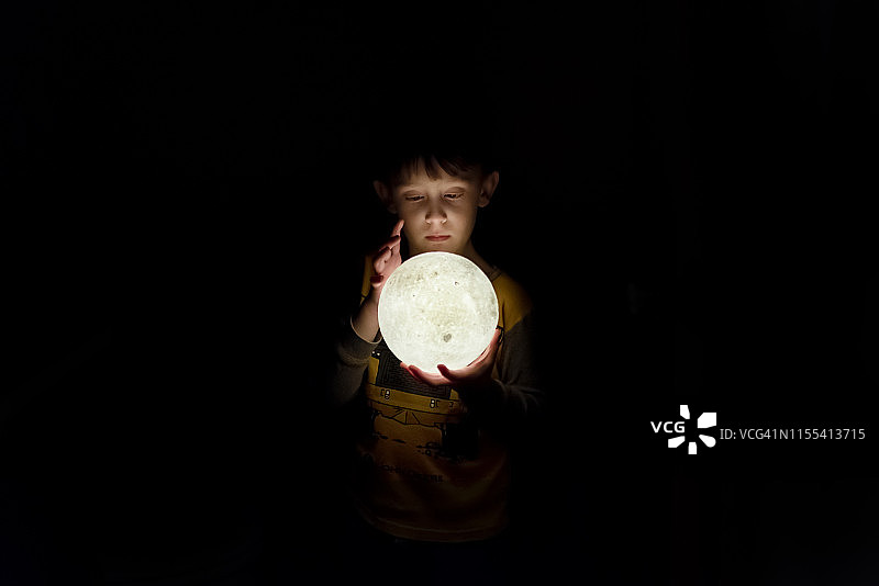 小男孩看一个3D月亮灯图片素材