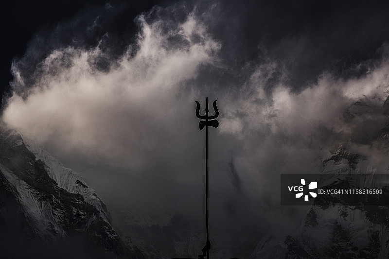 三叉戟在旋转的云和光在山顶上的安纳布尔纳基地营地，喜马拉雅山，尼泊尔图片素材