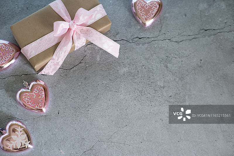 时尚礼品或礼品盒与金色蝴蝶结和星星五彩纸屑在粉红色的蜡笔桌顶视图。生日、圣诞节或婚礼用的平铺排版。图片素材