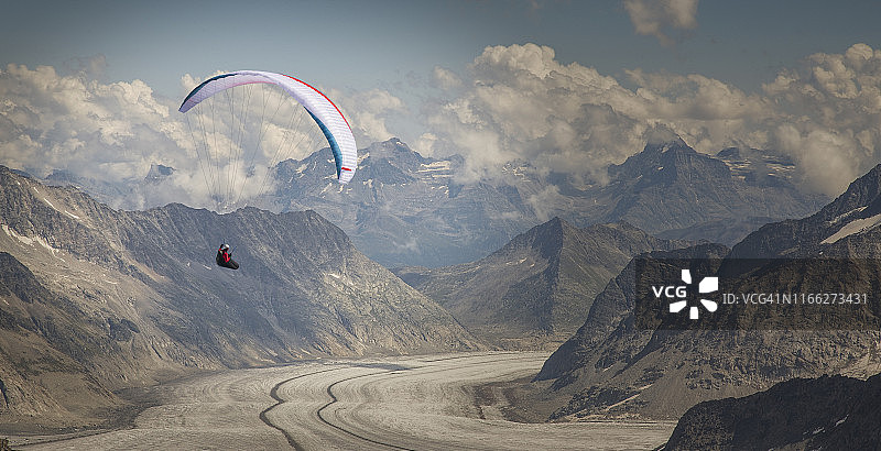 山谷中的滑翔伞飞越冰川图片素材