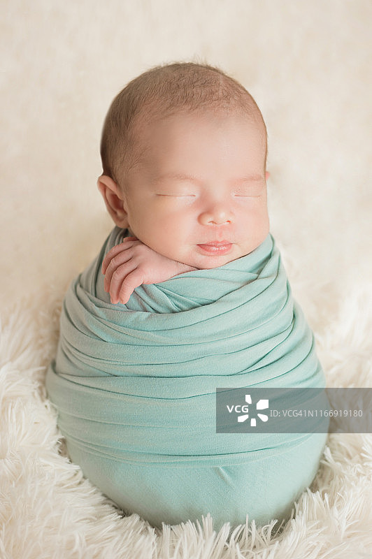 可爱的新生婴儿睡在舒适的房间。可爱快乐的婴儿肖像与睡脸在床上。柔焦婴儿的眼睛。新生儿保育概念。图片素材