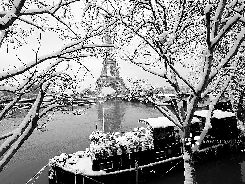法国巴黎16区，面对艾菲尔铁塔的塞纳河上的一艘船被雪覆盖图片素材