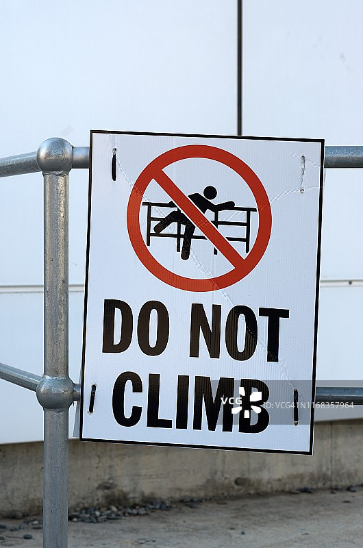 金属栏杆上的“请勿攀爬”警告标志图片素材