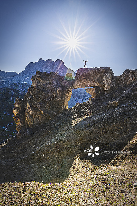 徒步旅行者在一个天然石拱上。恩加丁、瑞士图片素材