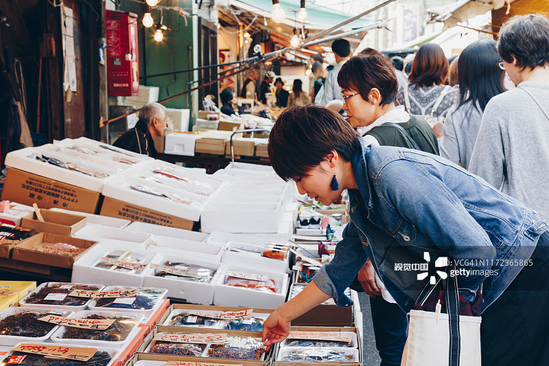 年轻的亚洲女游客和日本人像往常一样在东京筑地鱼市购物和旅游，图片素材