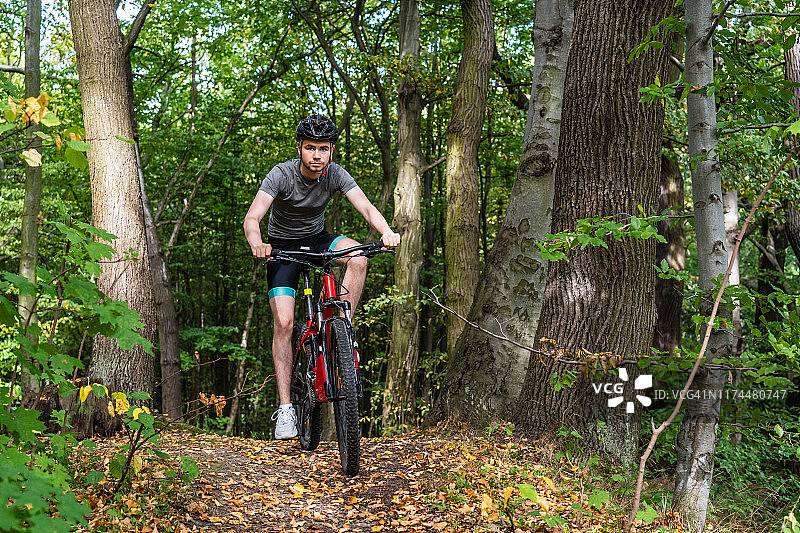 在森林里骑自行车的年轻人图片素材
