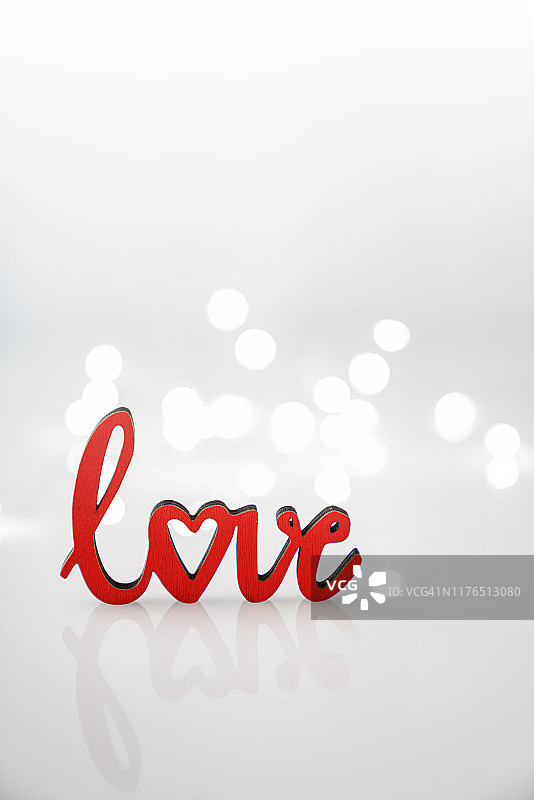 英文中的“爱”字是白色背景上的红色木制字母。情人的爱。图片素材