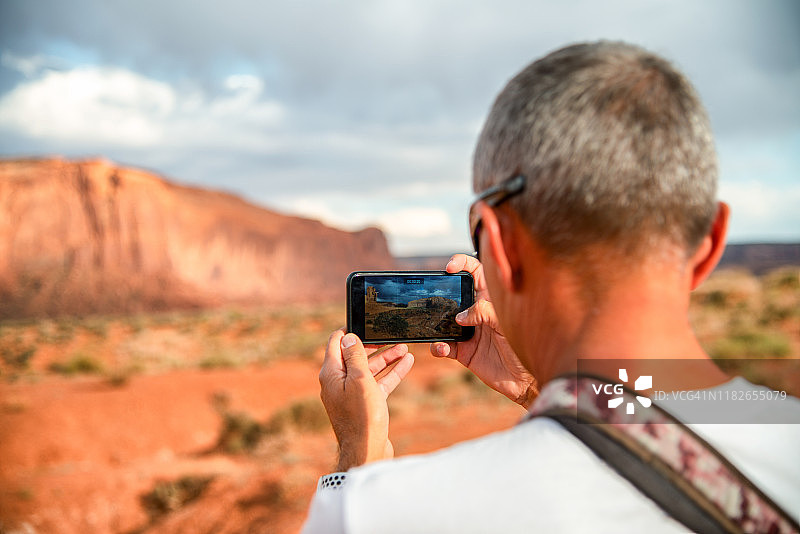 独自旅行者。一个度假的游客在拍摄风景。纪念碑山谷,犹他州图片素材