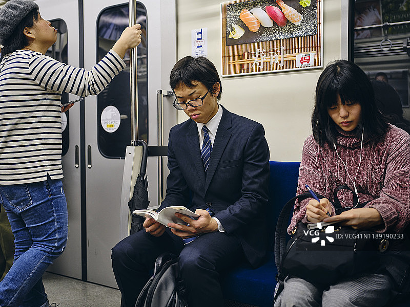 拥挤的日本地铁上的年轻女子图片素材