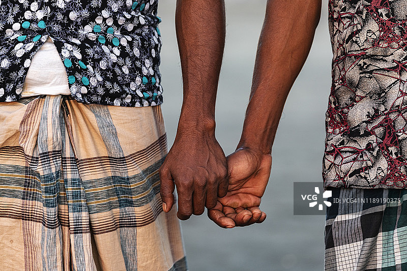 男人们手牵着手在考克斯的巴扎海滩图片素材
