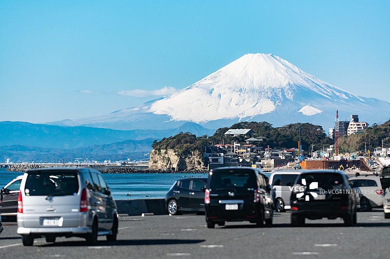 日本神奈川县，积雪覆盖的富士山和海边的停车场图片素材