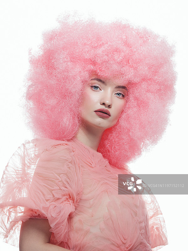 漂亮的年轻女子，一头粉红色的卷发图片素材