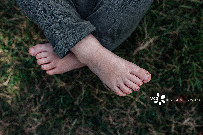 草地里孩子的脏脚趾。图片素材