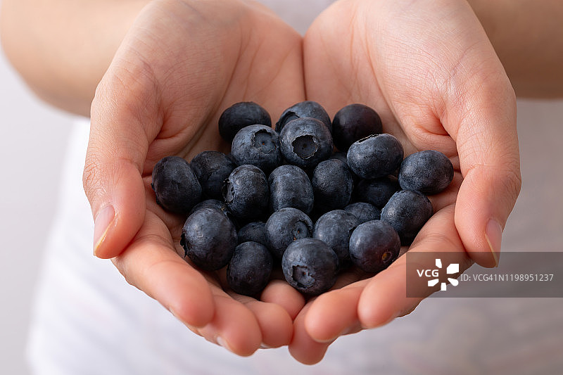 女性手握蓝莓，健康食品。图片素材