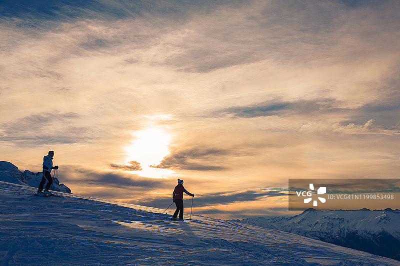 业余冬季运动高山滑雪。朋友女人和男人滑雪者享受在阳光明媚的滑雪场。高山雪景。阿尔卑斯山，欧洲，意大利。图片素材