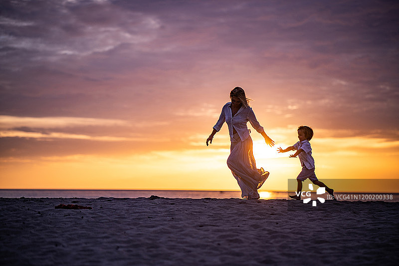 美丽的日落和母子在海滩上图片素材