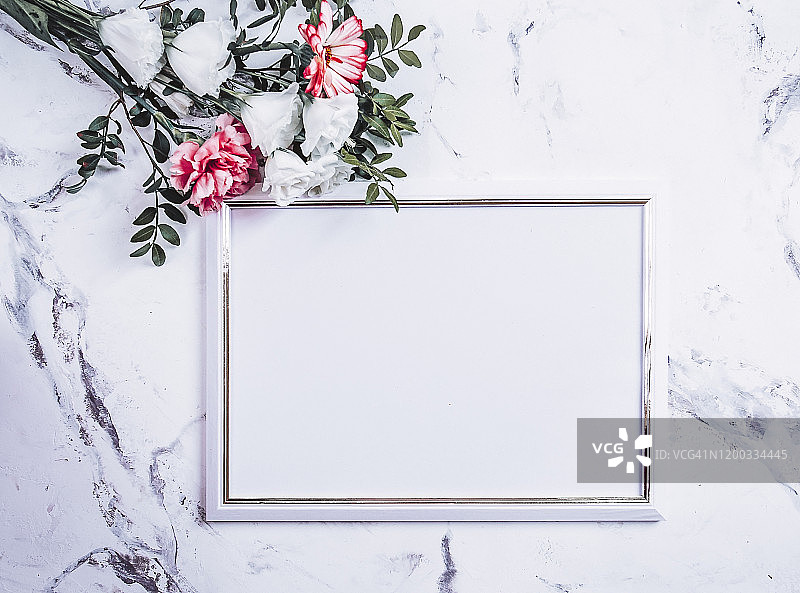 空白的画框和白色的花束花在大理石桌子背景图片素材