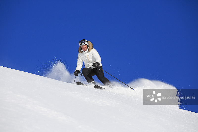 业余冬季运动高山滑雪。男子滑雪者在阳光明媚的滑雪场滑雪。高山雪景。阿尔卑斯山，欧洲，意大利。图片素材