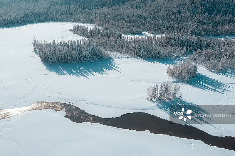一条河流穿过冬季森林的鸟瞰图图片素材