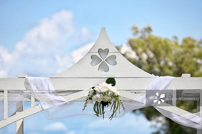 一个阳光明媚的夏日，白色的婚礼祭坛图片素材