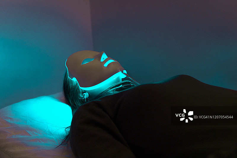 一位年轻女性的LED面膜再生治疗图片素材