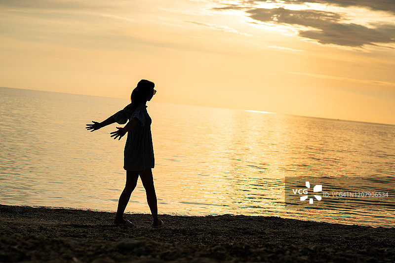 日落时沙滩上的女人图片素材