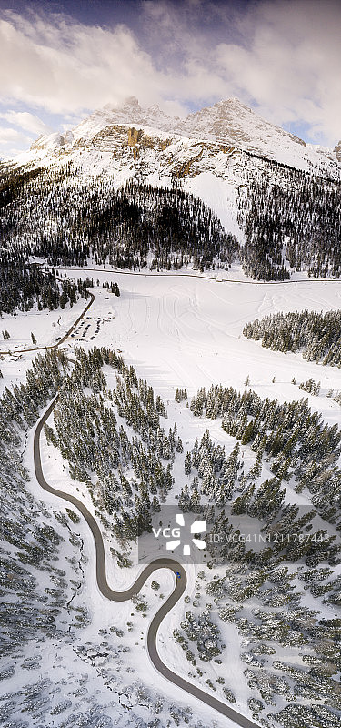 蜿蜒的道路沿着雪林，鸟瞰图，安托诺-米苏里纳，Dolomites，意大利图片素材