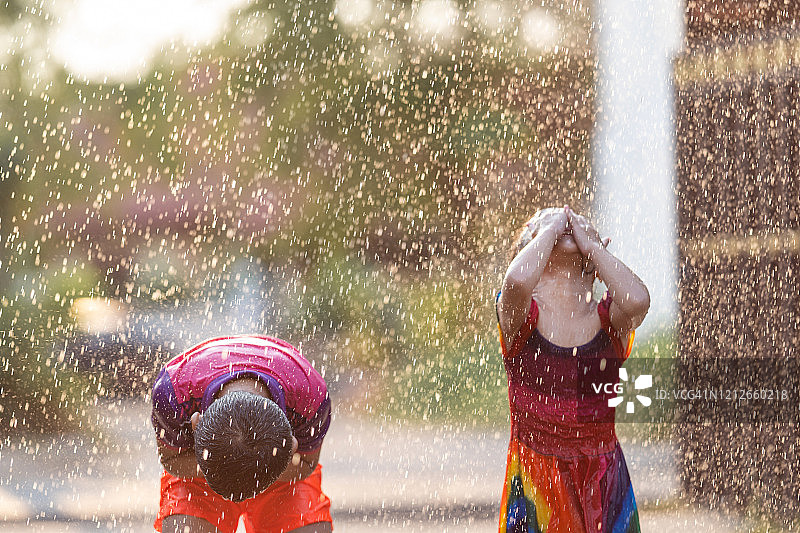 在雨中玩耍的亚洲孩子是快乐的。图片素材