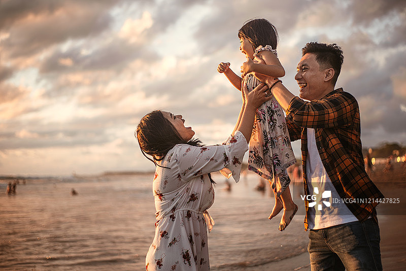 快乐的家庭在海滩上玩耍图片素材
