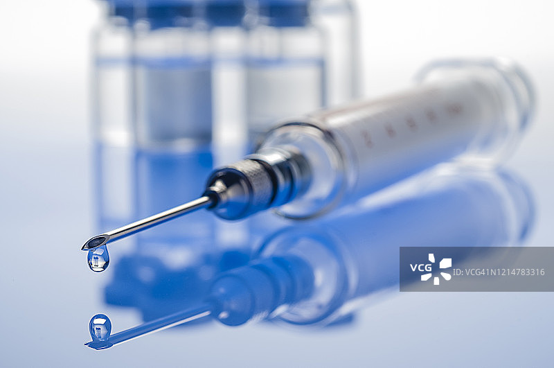 冠状病毒疫苗:蓝色背景注射器图片素材