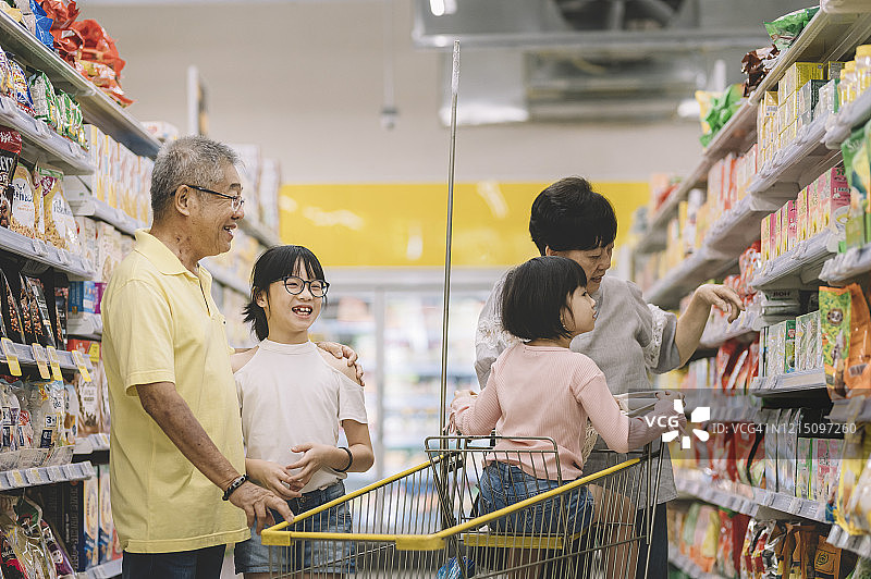 周末祖父母和孙辈在超市购物的瞬间图片素材