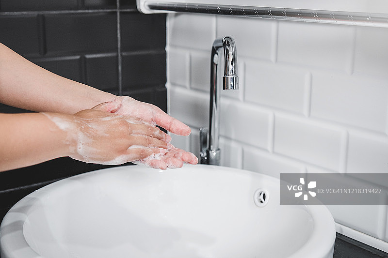 亚洲妇女用肥皂彻底洗手，以预防冠状病毒图片素材