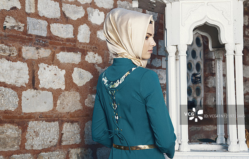 后视图美丽年轻的穆斯林妇女在谦虚的衣服图片素材