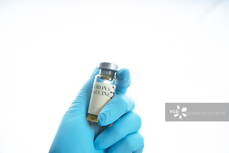 从冠状病毒(Covid-19)医疗设备的概念，靠近戴着手术手套、手持疫苗瓶和amp的医生，进行预防、免疫和治疗图片素材