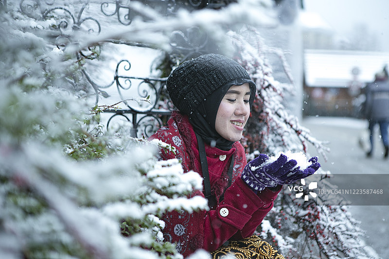 亚洲穆斯林游客在哈尔斯塔特享受冬天的雪图片素材