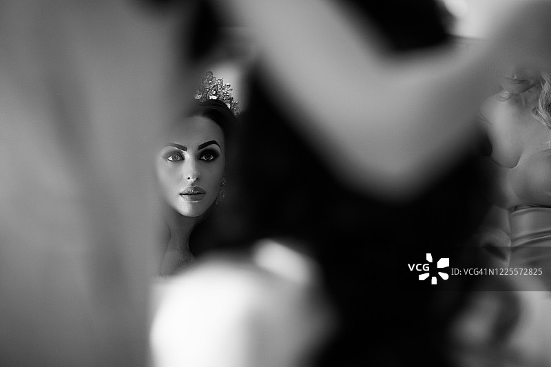 美丽的黑发新娘看着镜子里的自己图片素材