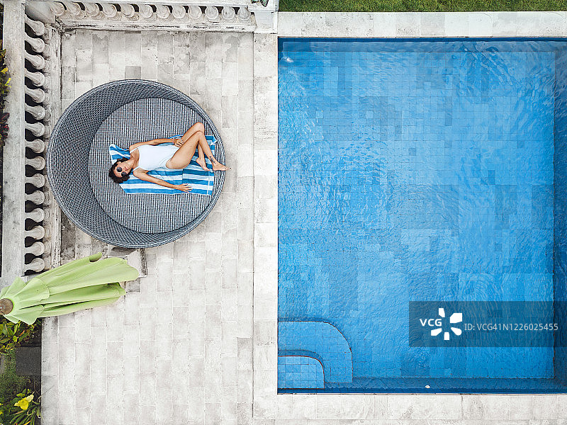 鸟瞰图迷人的女人附近的游泳池在度假村图片素材