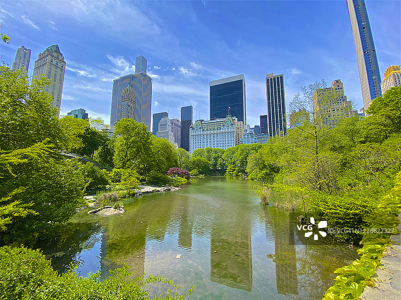 曼哈顿的天际线反映在中央公园池塘，纽约图片素材