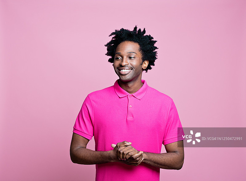 一个穿着粉红色polo衫的友好的年轻人的肖像图片素材