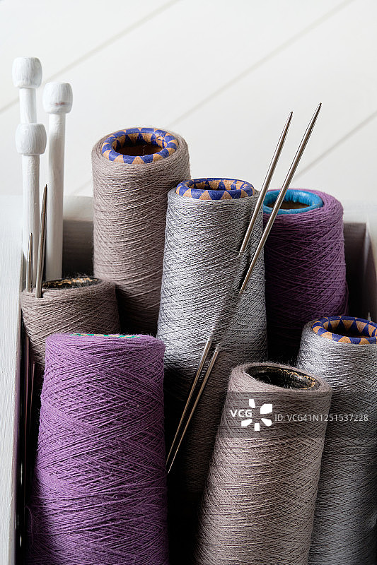 彩色的意大利毛线、毛线和毛线球，编织针，在一个木箱里，在白色的背景上。针织、针线、手工的概念。图片素材